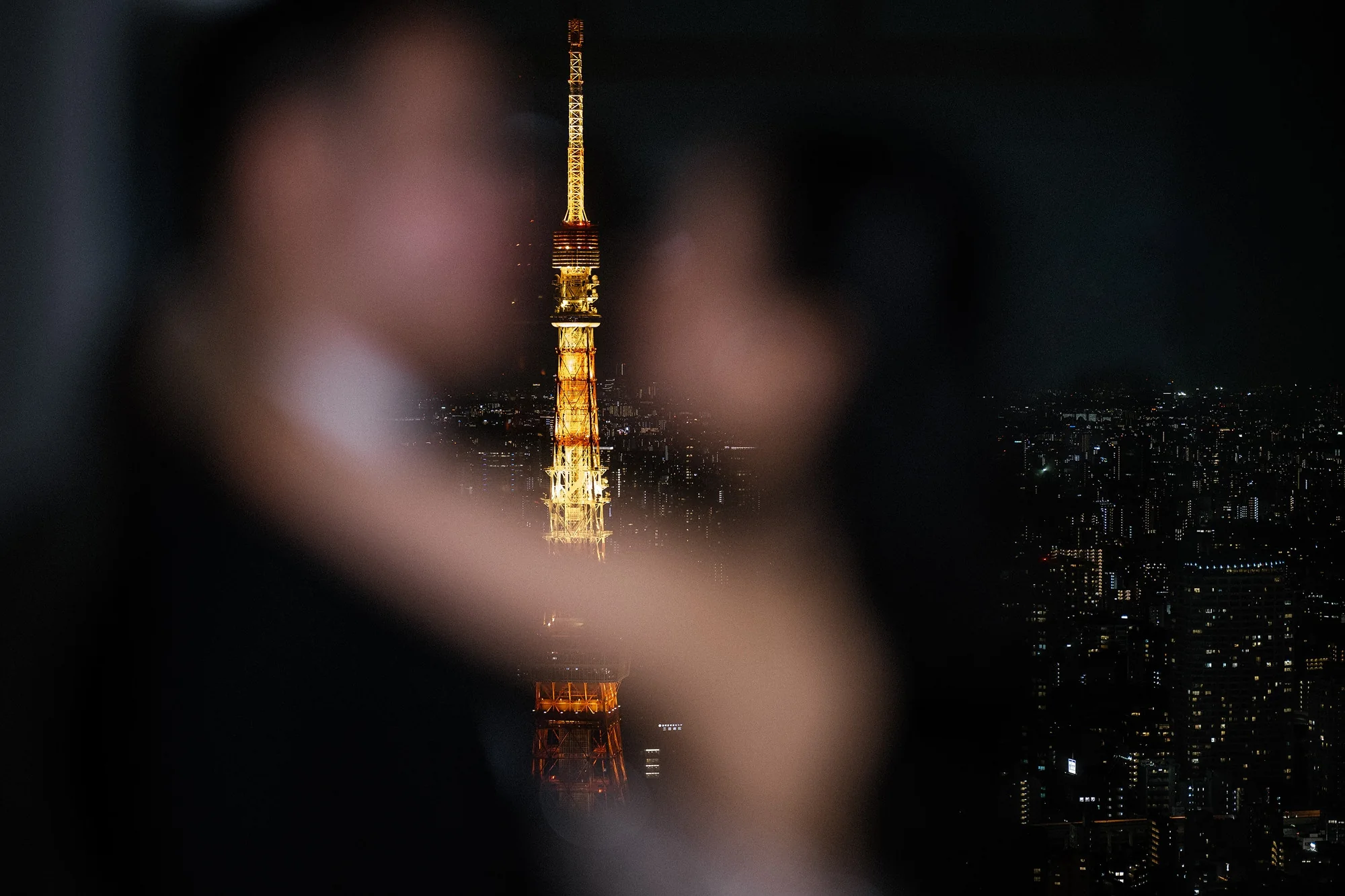 The couple dance close as Tokyo Tower glows behind them.