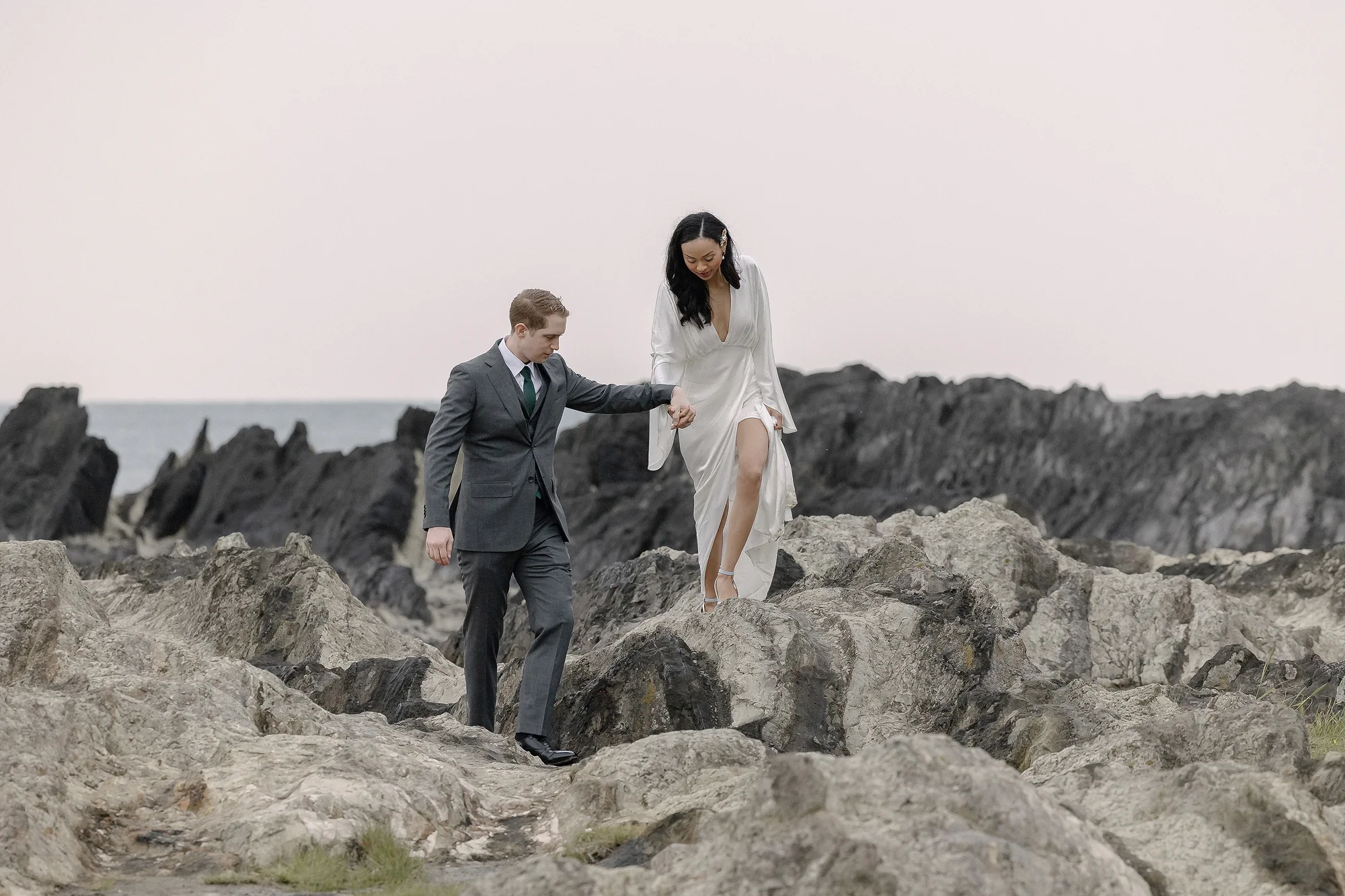 A couple pick their way across the rocks of the Miura coast.
