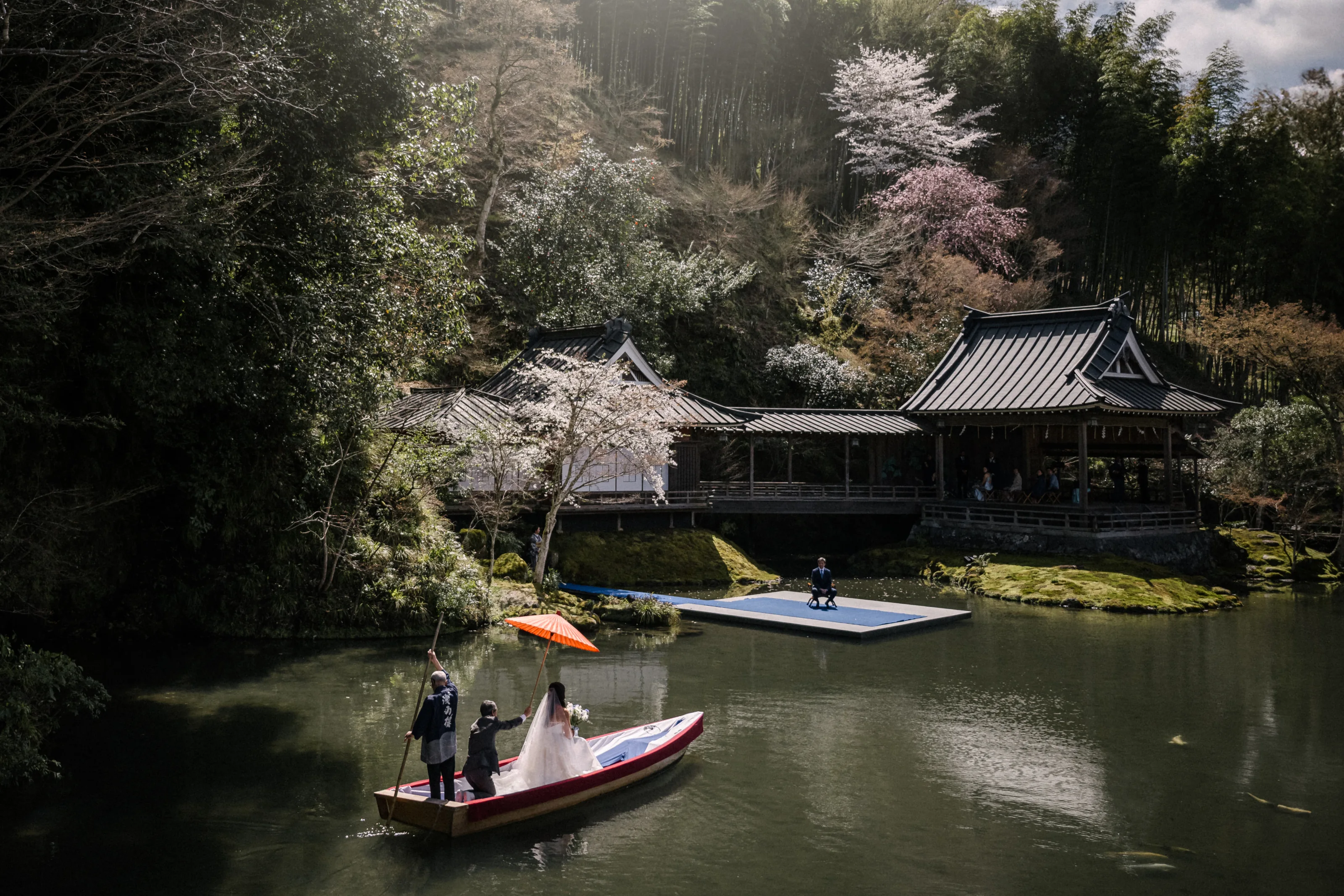 A bride arrives by boat across the pond at Asaba Ryokan.