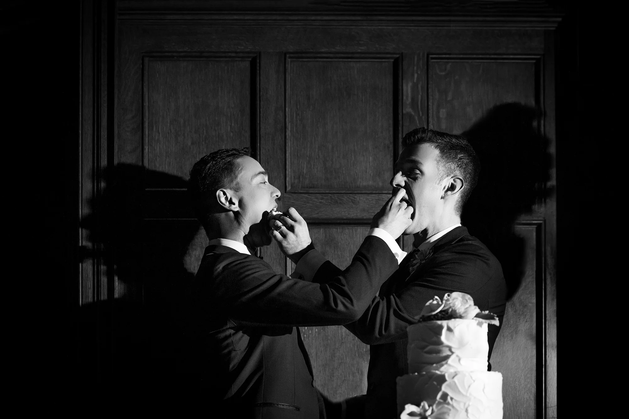 In black and white, the couple feed each other cake in a pool of light in Georgia.