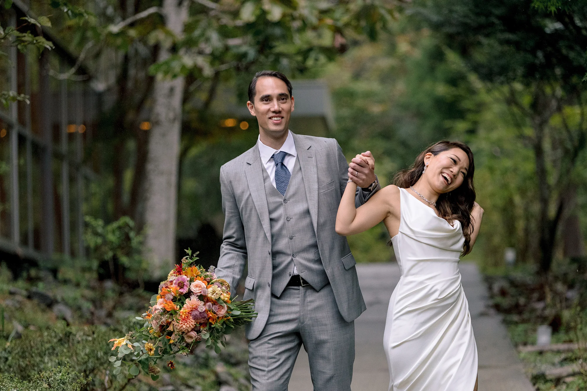 The newlyweds laugh as they walk hand in hand along a garden path in Hakone, an autumn bouquet in his hand.
