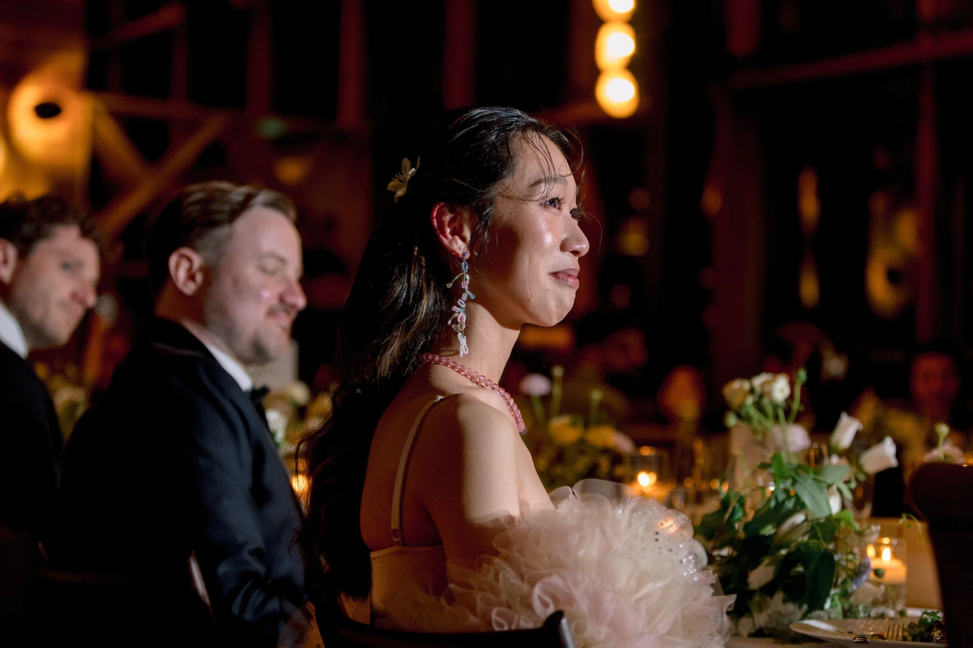The bride listens to the speeches at a candlelit reception in Hakone.