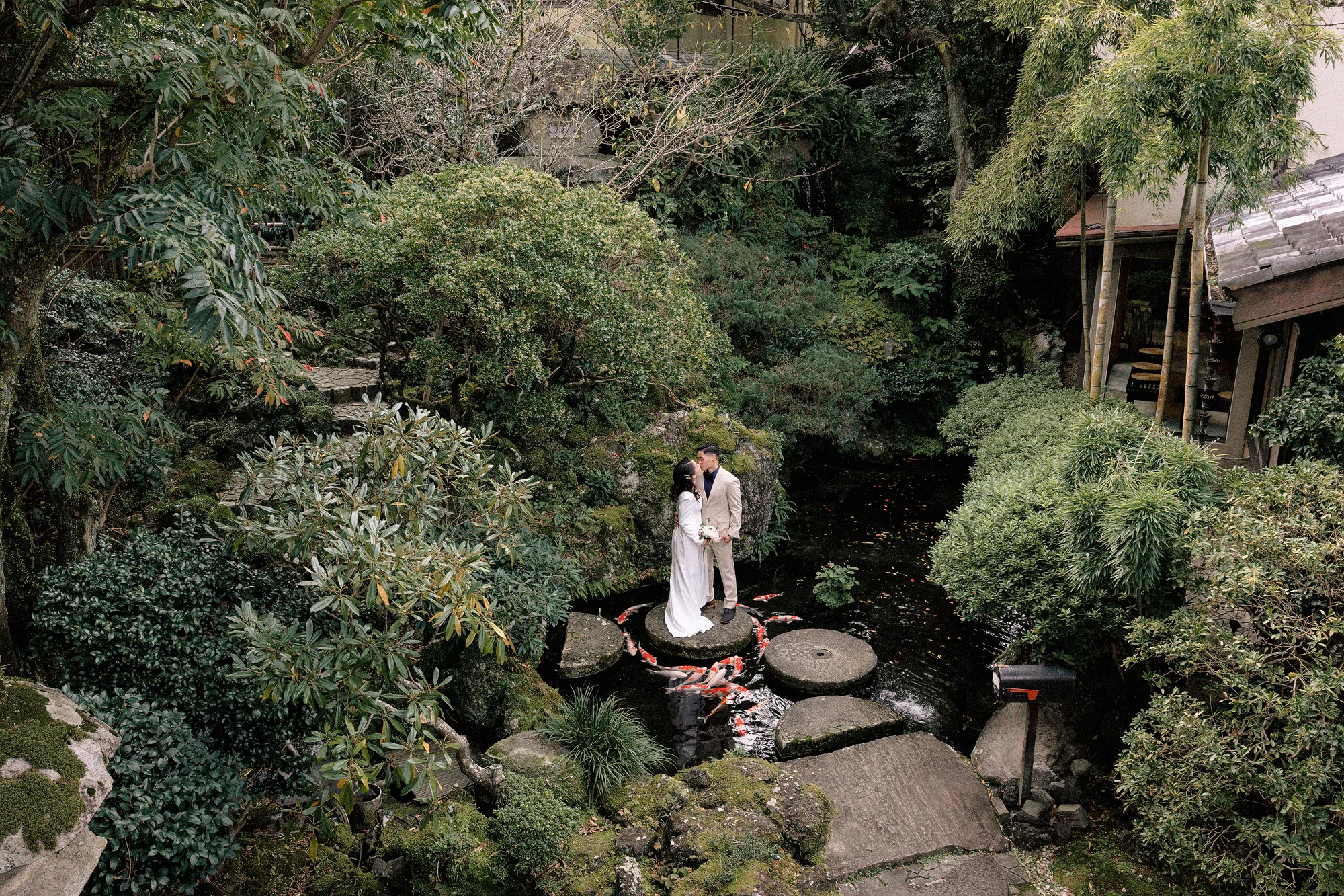 A couple step across a ryokan pond in Izu.
