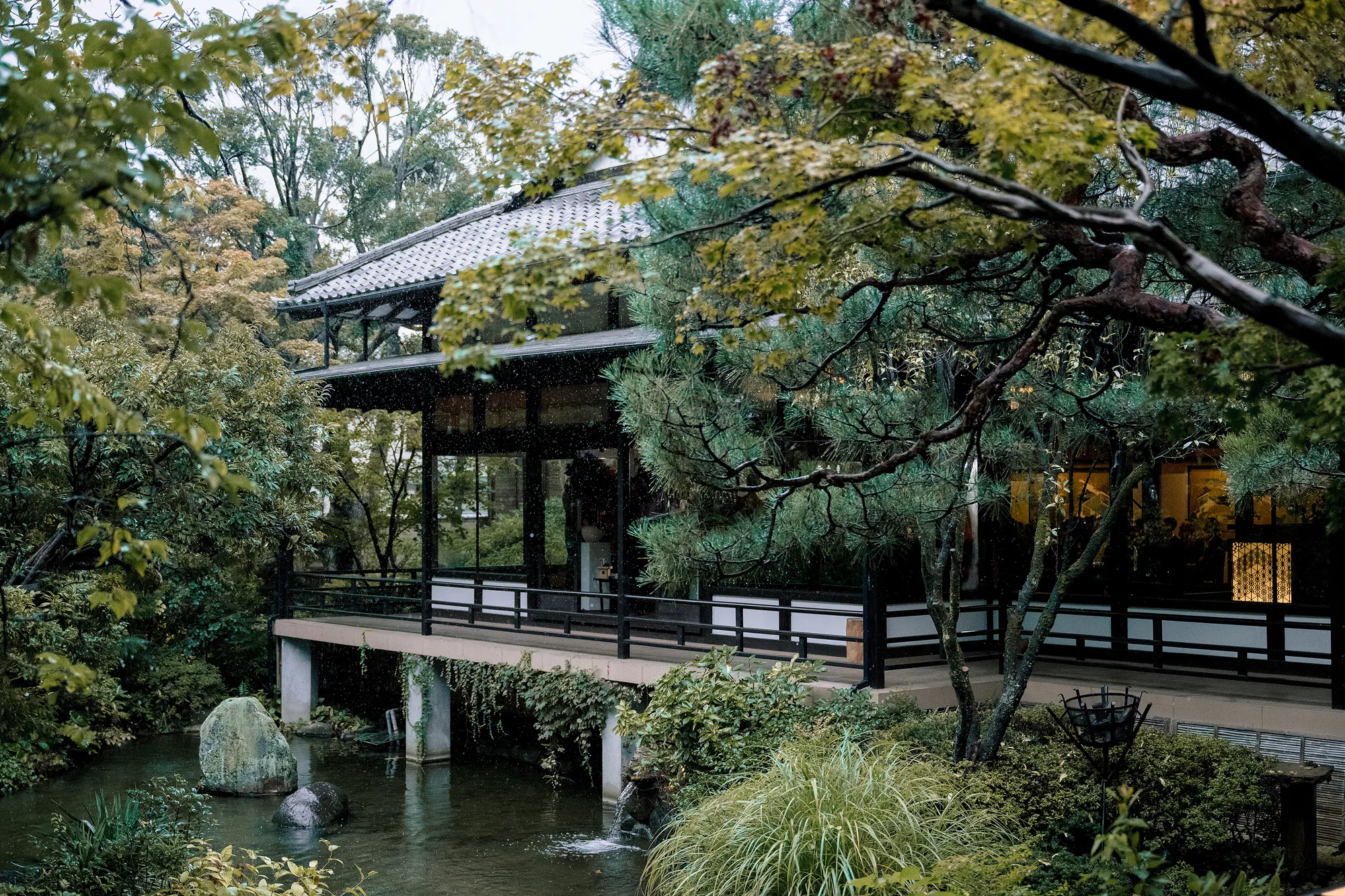 The pavilion of the Jinya wedding venue standing over the garden pond among pines.