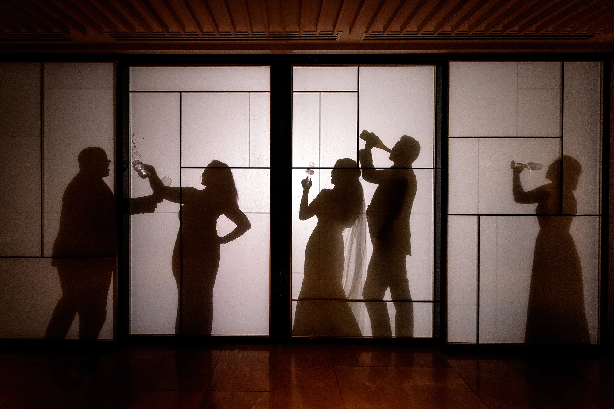 Guests' silhouettes play across lit shoji screens as they drink and dance in Kyoto.