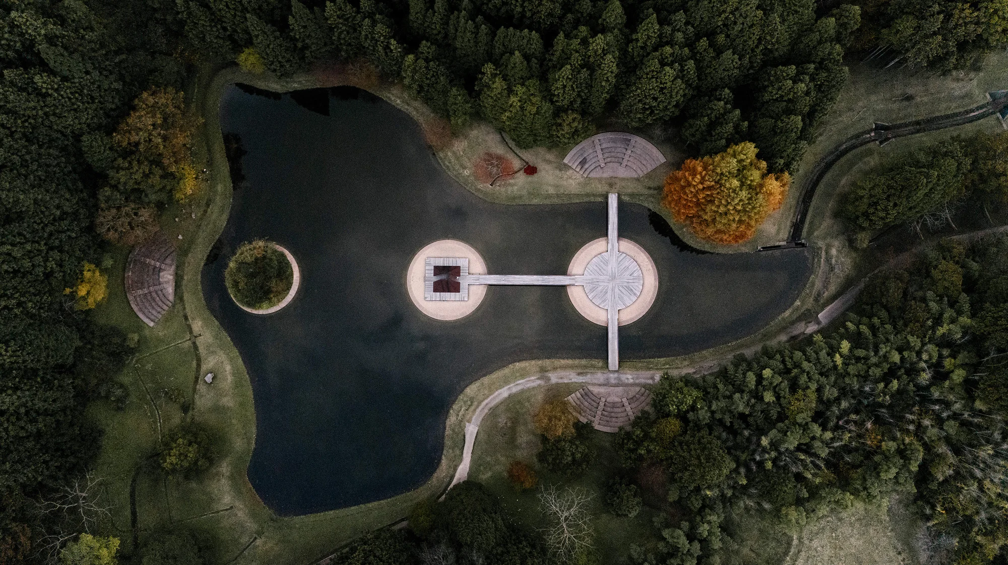 From above, a pond with islands and a white walkway at the art forest in Nara.