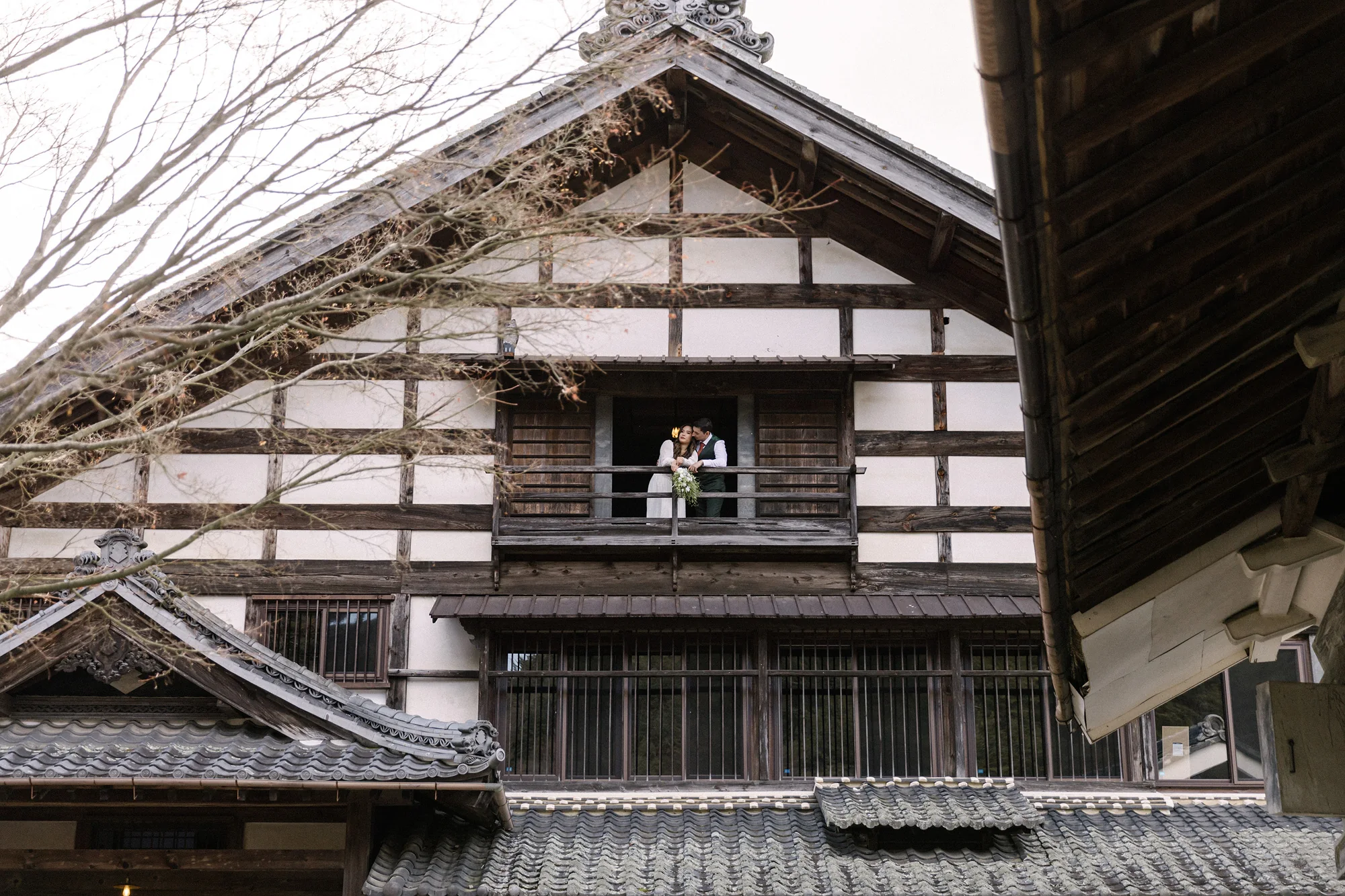 A couple on the balcony of a historic timber building.