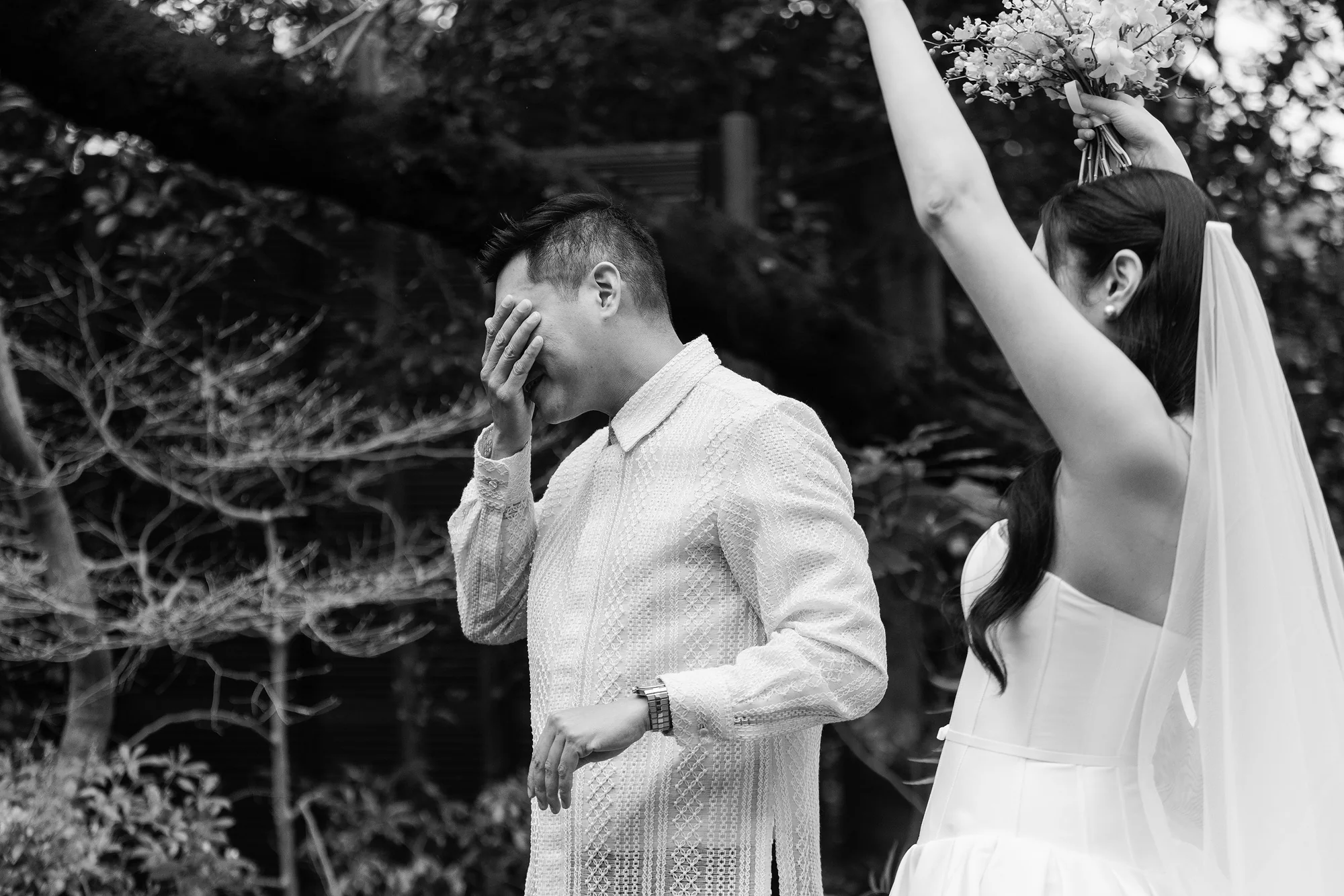 In black and white, the groom reacts as he sees the bride for the first time.