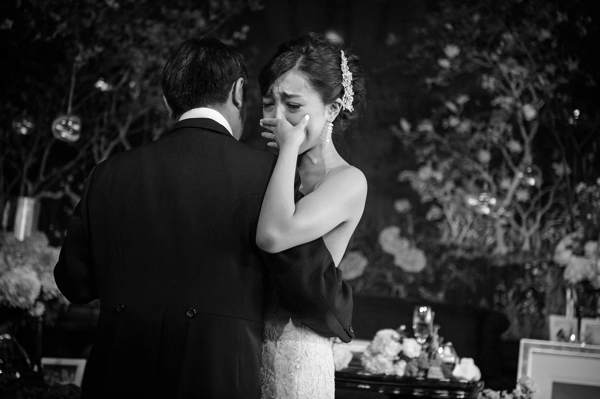In black and white, the bride wipes away a tear as she dances with the groom at the Shangri-La Tokyo.