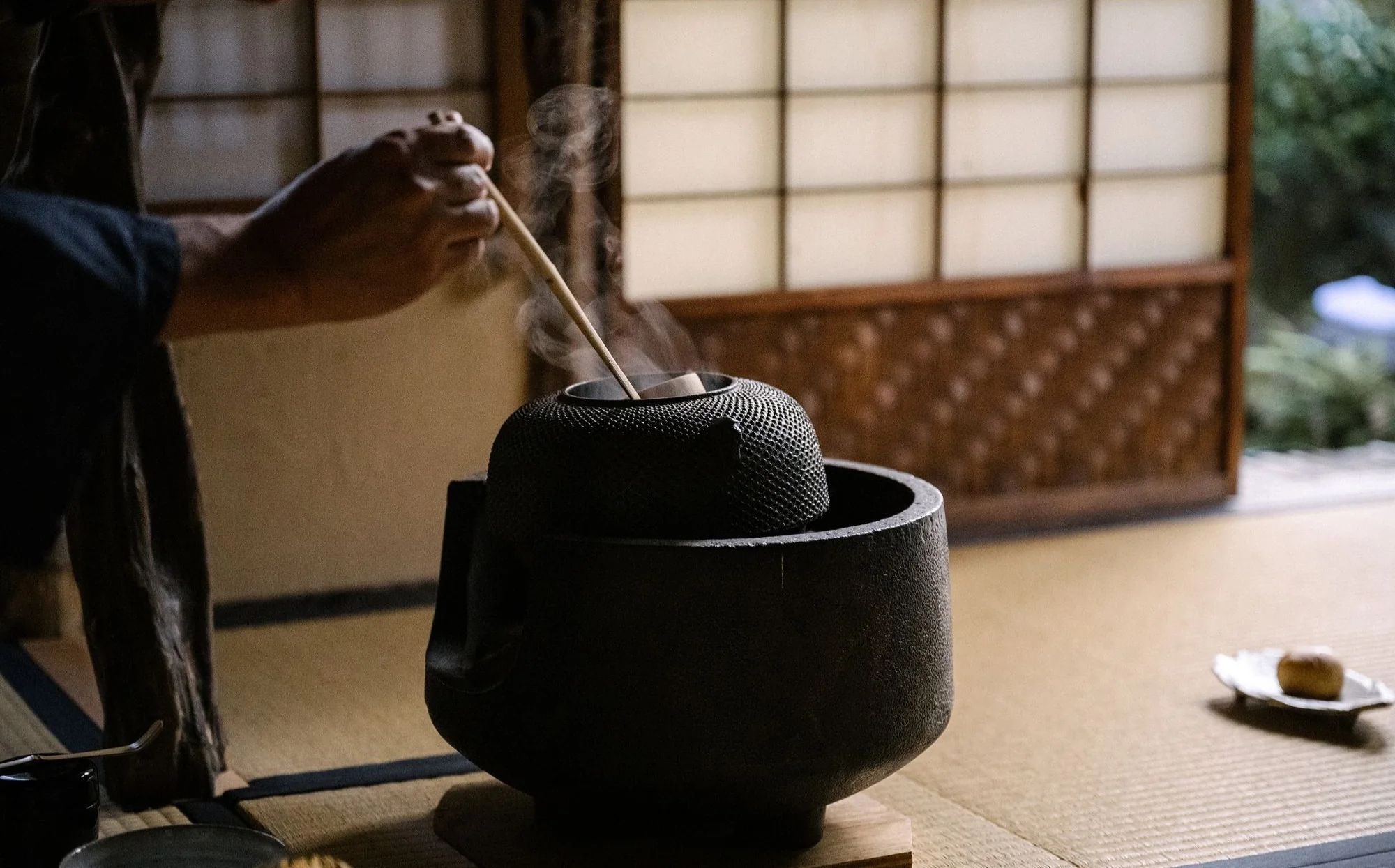 Steam rises from an iron kettle as matcha is prepared on tatami for the couple's tea ceremony.