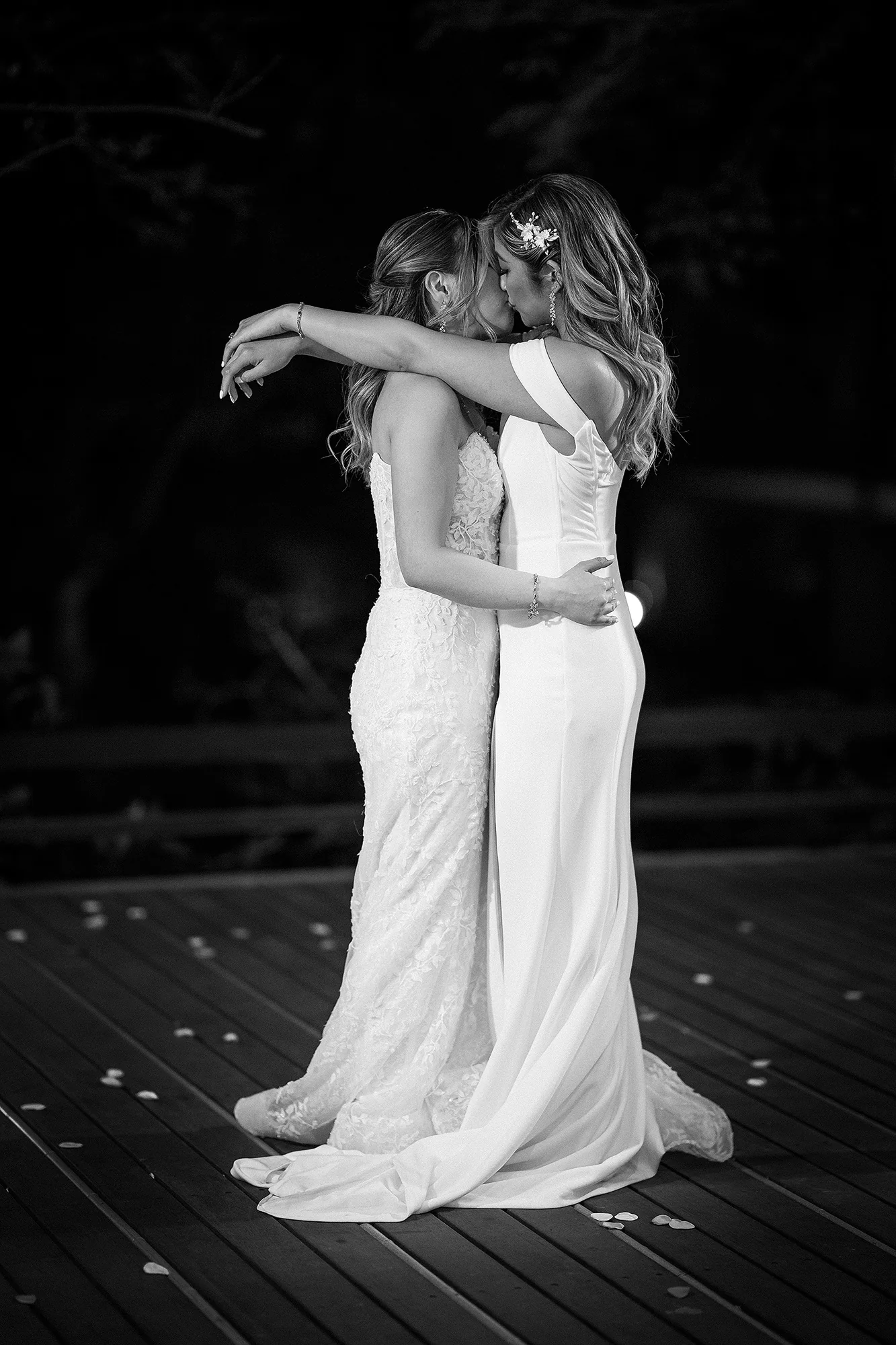 In black and white, two brides hold each other close in their first dance at Jinya.