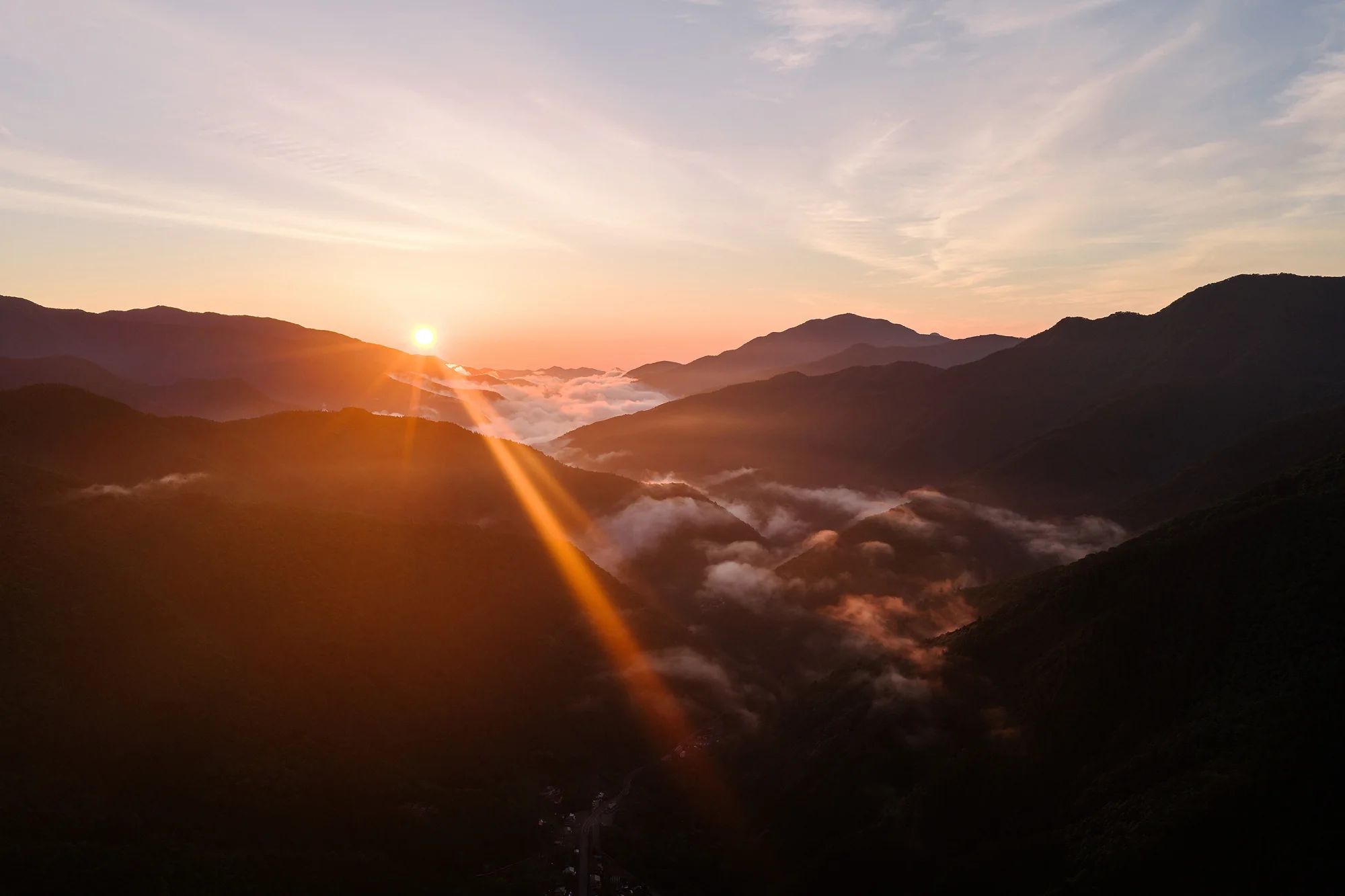 Sunrise over forested mountains and a sea of cloud in the hills of Yamanashi.